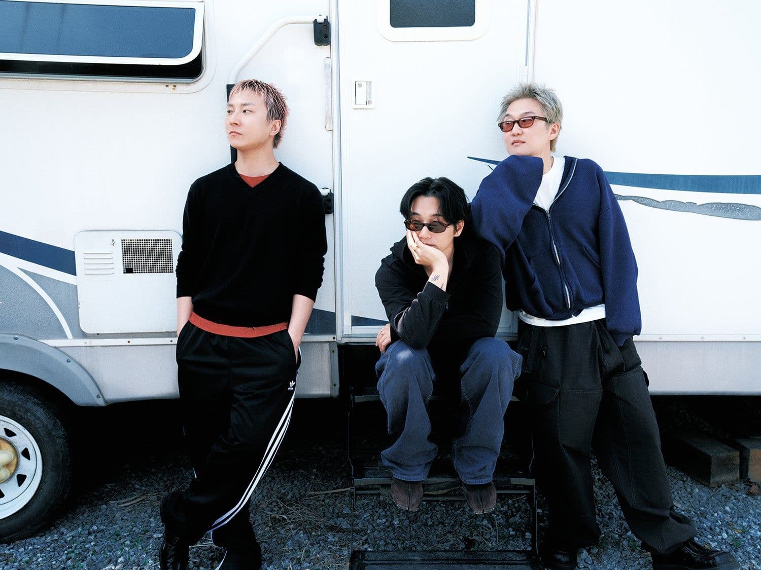 The three members of wave to earth pose in front of their tour vehicle.