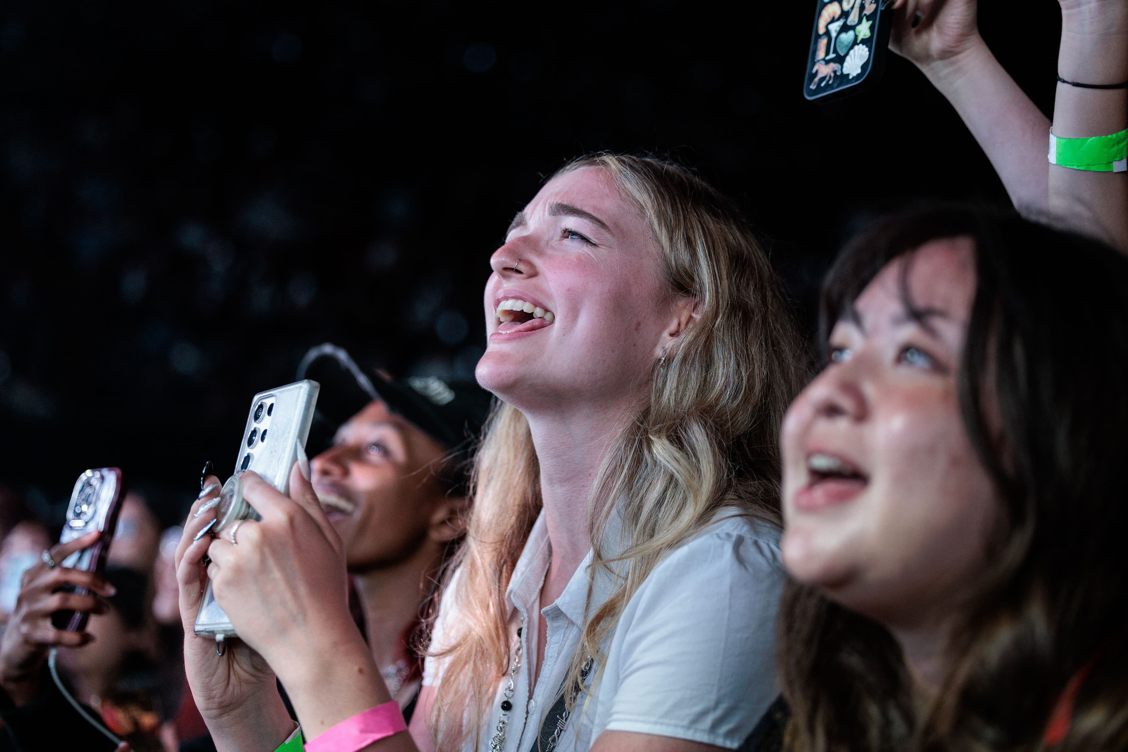 Fans at the barricade smile and sing toward the stage while holding their phones during keshi’s performance.