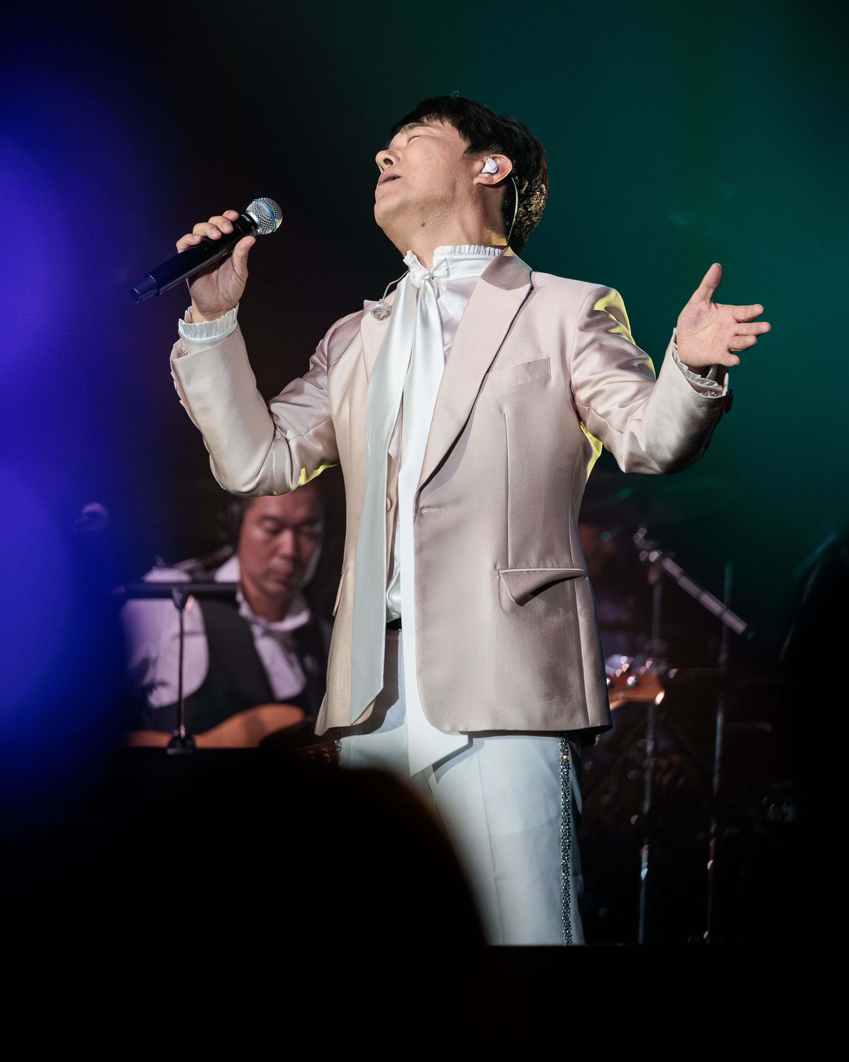 Lim Chang-jung sings with his eyes closed under the stage lights during his Pechanga performance.