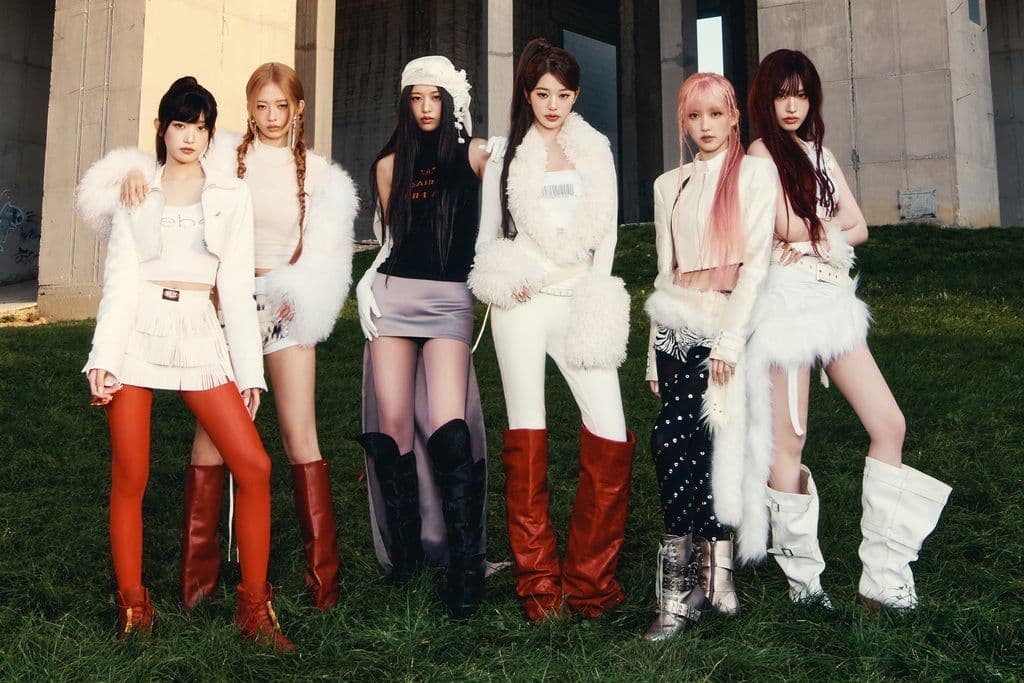 IVE pose together beneath a concrete overpass in coordinated white and red outfits.