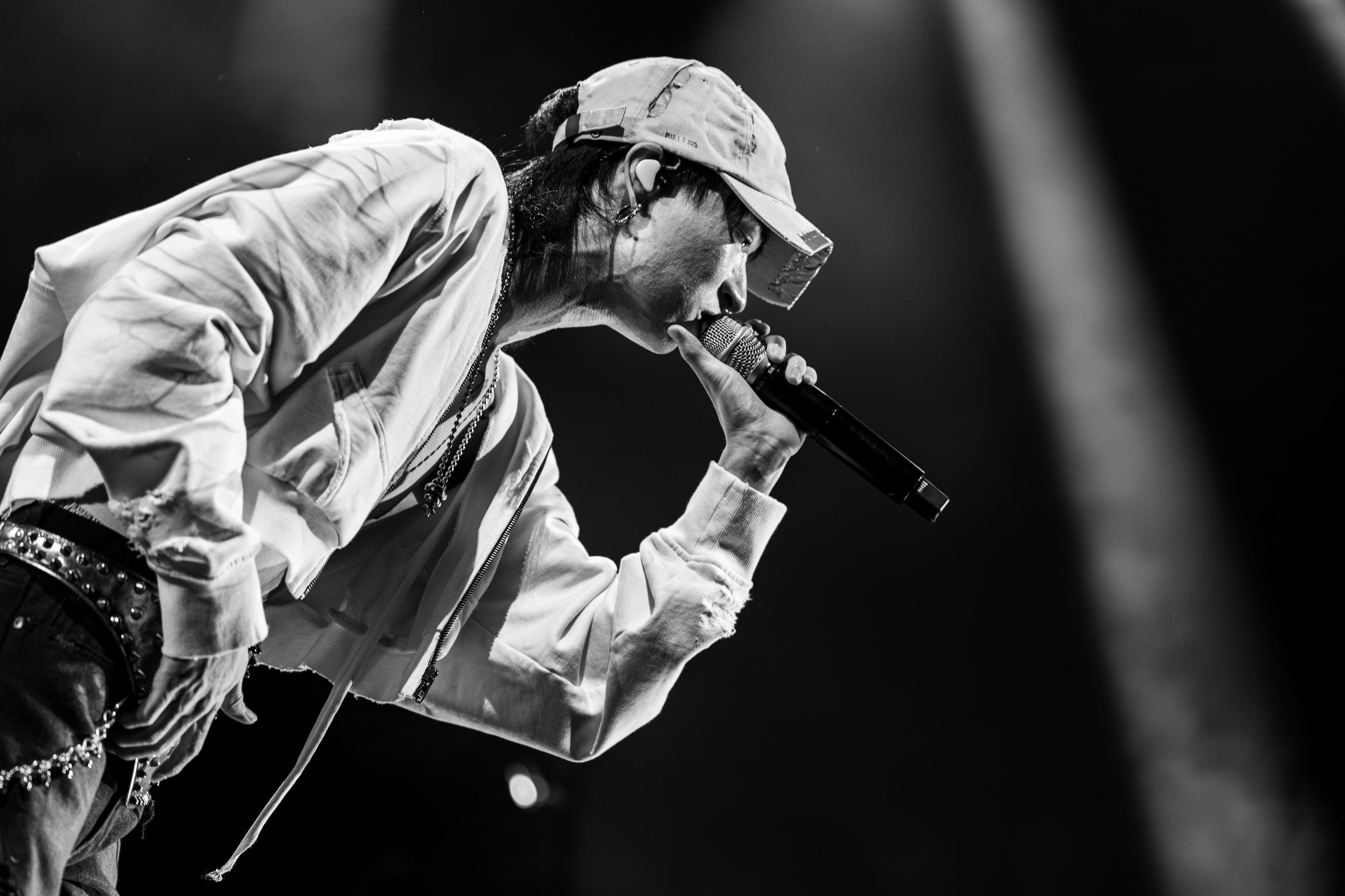 keshi leans forward into his microphone during a black-and-white performance moment at the Kia Forum.