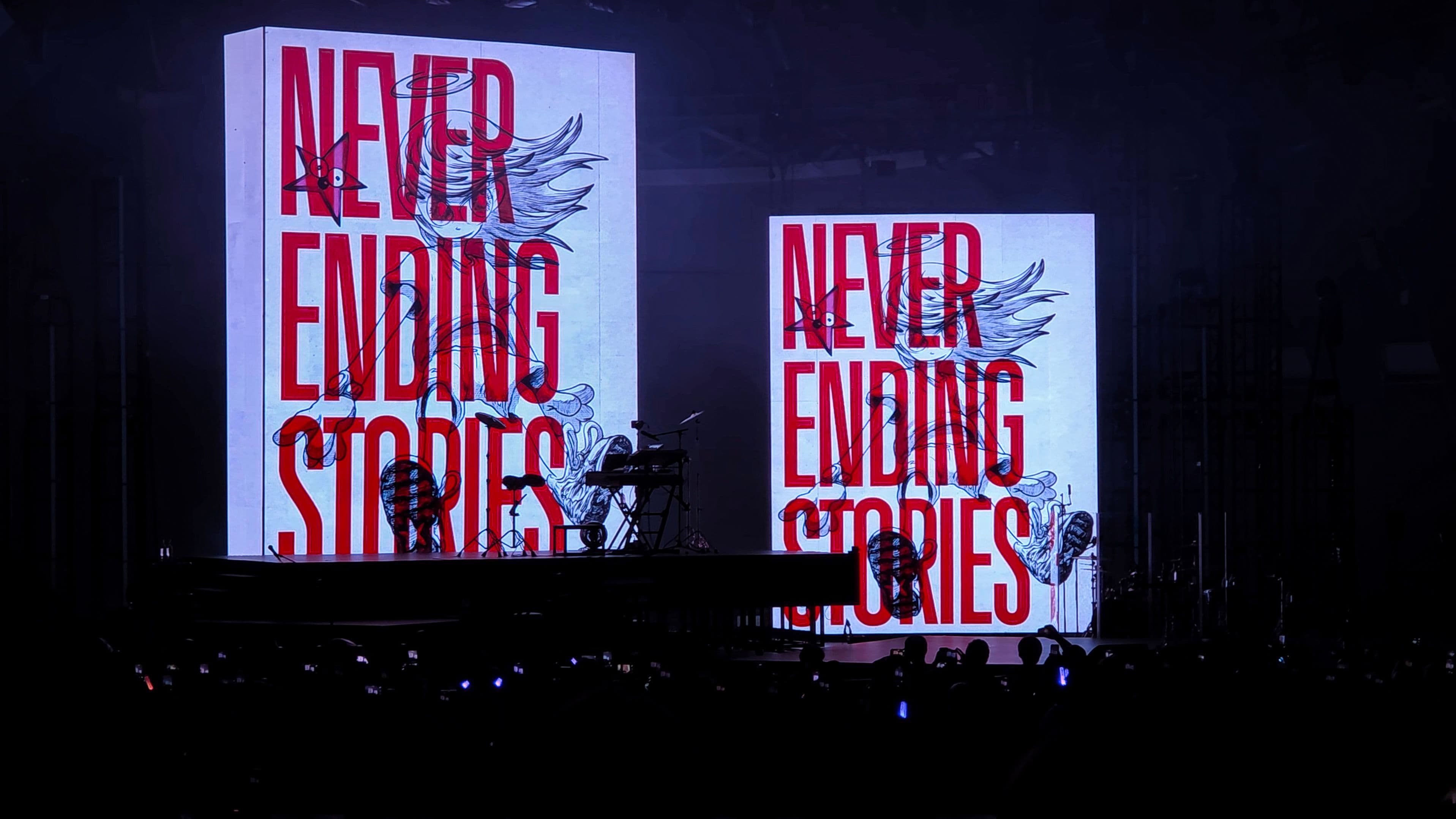 Two towering screens display the words “Never Ending Stories” above the stage during YOASOBI’s performance at the Hollywood Bowl.
