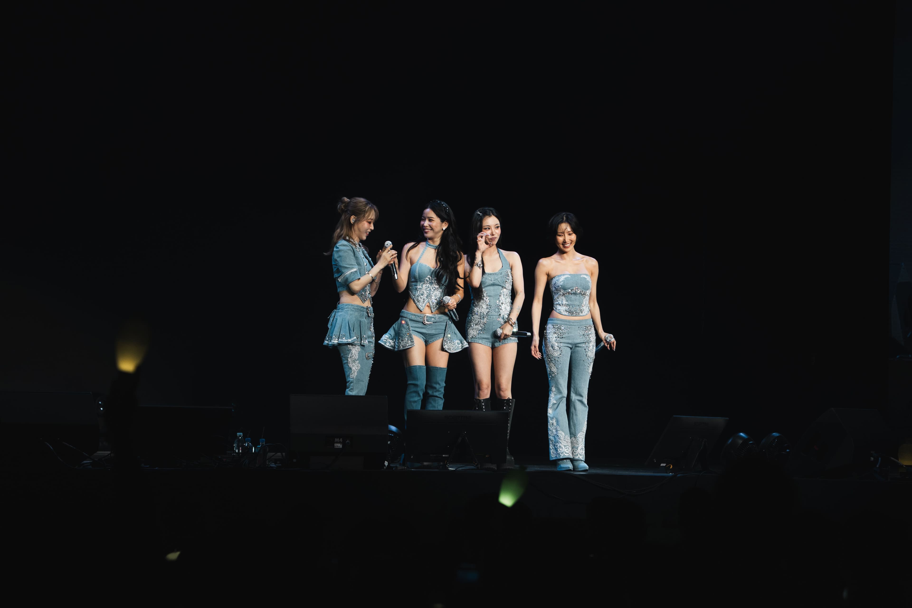 Solar, Moon Byul, Whee In and Hwa Sa stand together onstage smiling and becoming emotional near the end of MAMAMOO's Crypto.com Arena concert