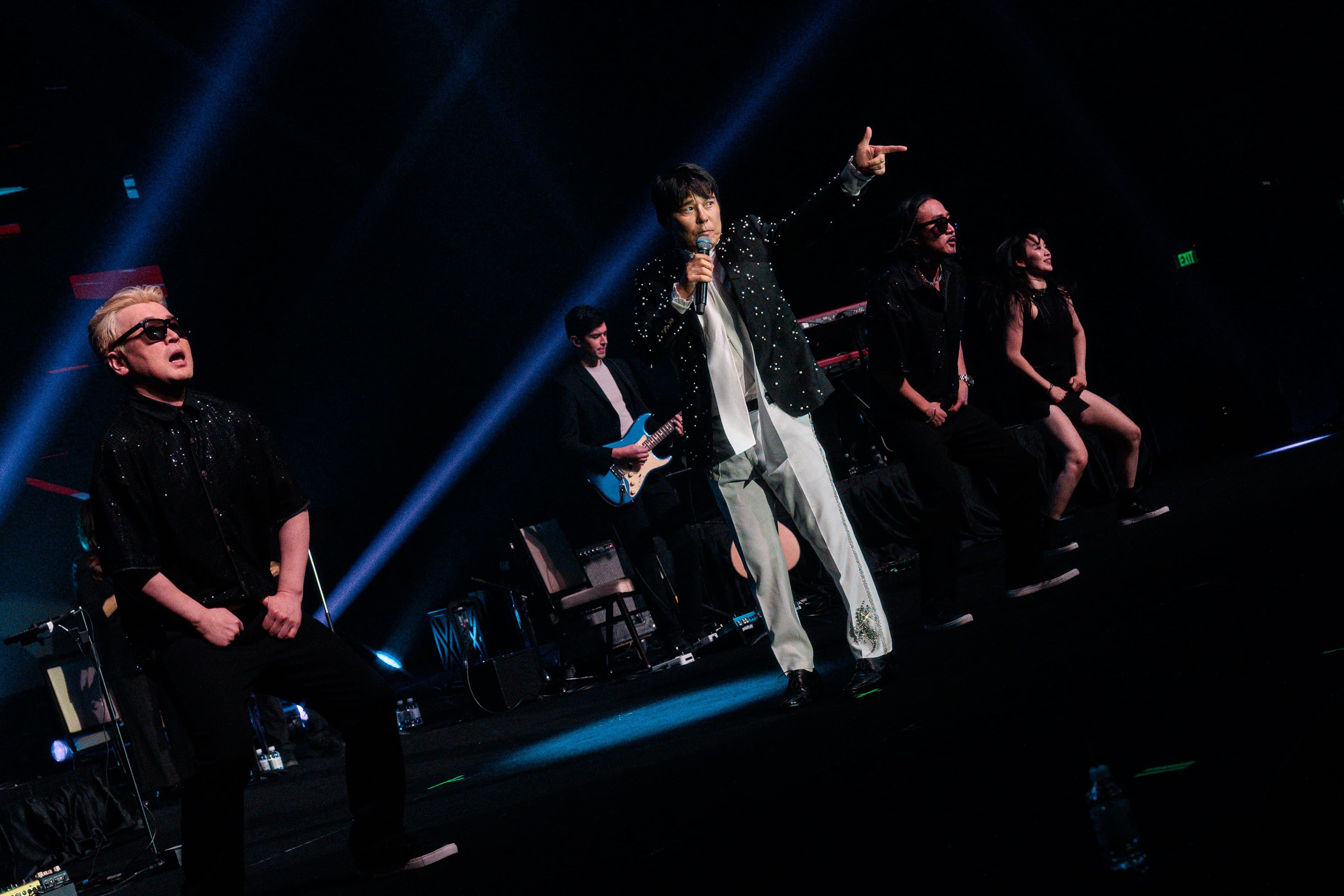 Lim Chang-jung performs at center stage alongside dancers and his band under blue lighting at Pechanga Summit.