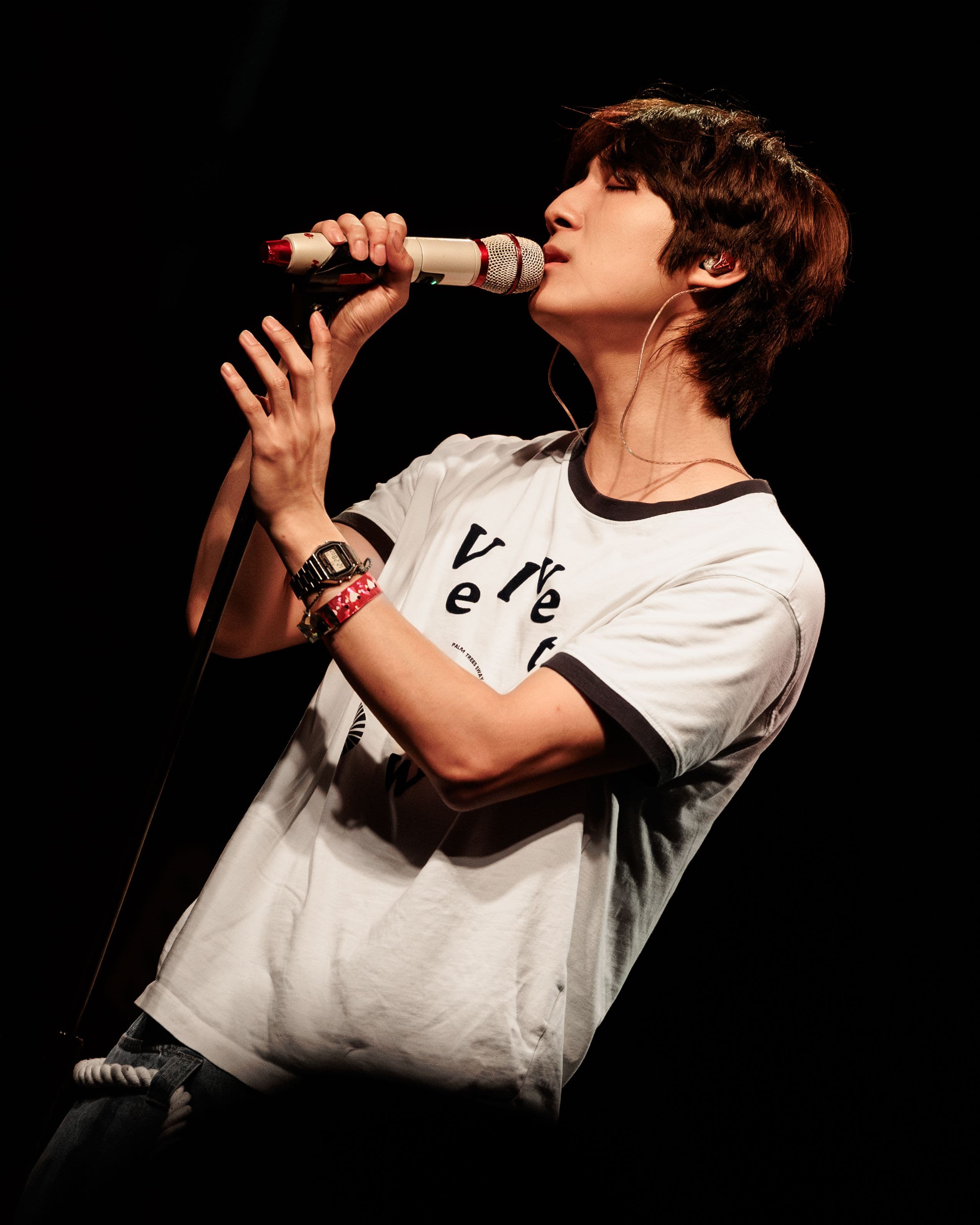 HOHYUN sings into a white microphone under warm stage lighting at the El Rey Theatre.