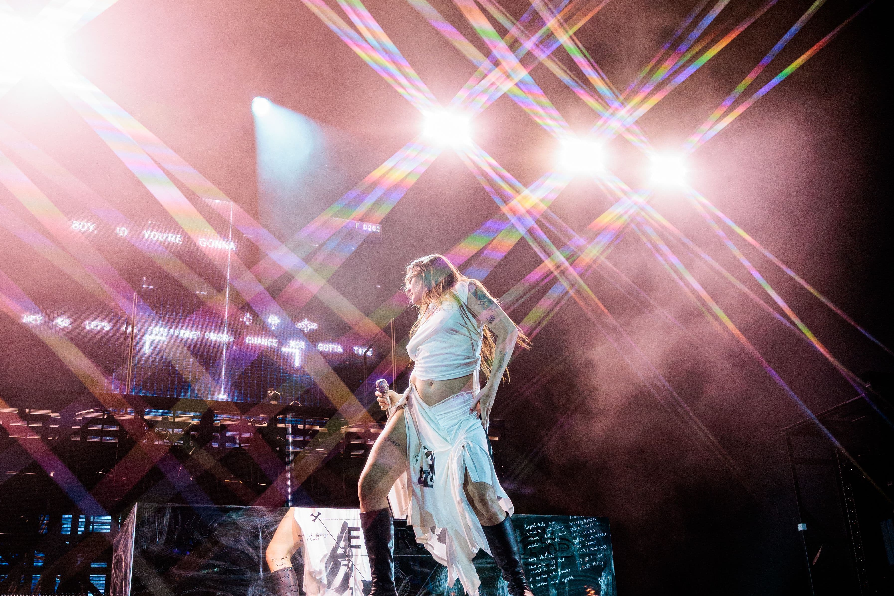 Tove Lo sings into a microphone from the edge of the stage during her ESTRUS Tour performance at the Greek Theatre.